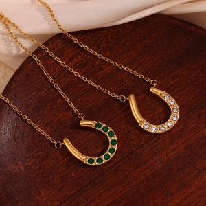 Detail von hufeisenförmigen 18K Goldanhängern mit grünen und weißen Edelsteinen