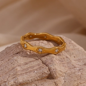 Close-up of wavy 18K gold plated ring with starburst pattern and embedded zircons