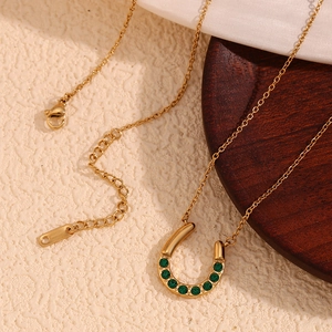 Detail der 18K vergoldeten Hufeisenkette mit grünen Steinen und verstellbarer Kette