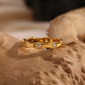Macro shot of 18K gold plated wavy ring featuring star settings with sparkling zircons