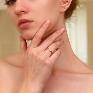 Detail of 18K gold plated wavy ring with three sparkling round zircons for women