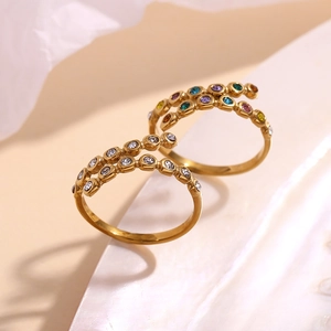 Macro detail of 18K gold plated crossover rings with white and colorful micro-set zircons