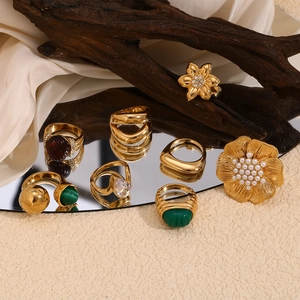 Macro view of vintage gold rings with turquoise and pearl details on mirror