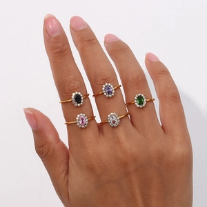 Dettaglio di cinque anelli placcati oro 18K con pietre di zircone colorate su una mano
