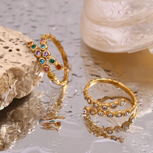 Detail of 18K gold-plated crisscross rings with colorful and white micro-set zircons
