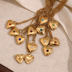 Macro detail of heart locket necklaces in gold with assorted birthstone crystals