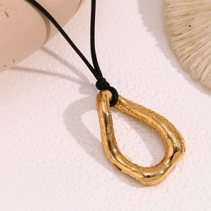 Macro shot of 18K gold plated irregular round pendant with molten lava texture and water drops