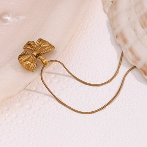 Détail du collier pendentif noeud en or 18 carats sur coquillage avec gouttes d'eau