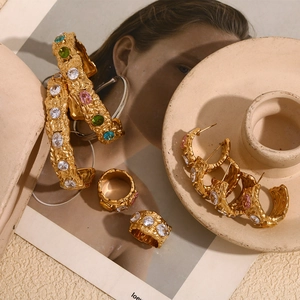 Detail van vintage 18K vergulde sieradenset met lavatextuur en kleurrijke edelstenen