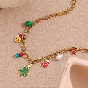 Detail van kerstketting met emaille hangers van de kerstman en boom in 18K goudfinish
