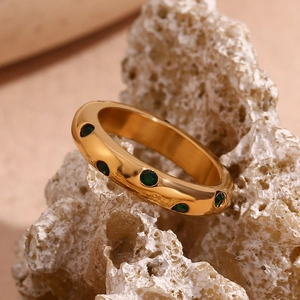 Detail eines 18K vergoldeten Rings mit mikroeingesetzten grünen runden Zirkonias