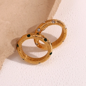 Makroaufnahme von 18K vergoldeten Ringen mit Hammerschlag-Optik und grünem Edelstein