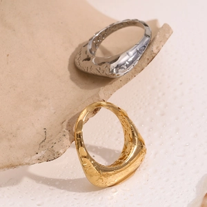 Detailed macro view of 18K gold and silver rings with irregular lava liquid metal texture