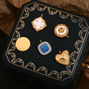 Detailaufnahme von Vintage 18K vergoldeten Anhängern mit Sternen, Herzen und Bienen