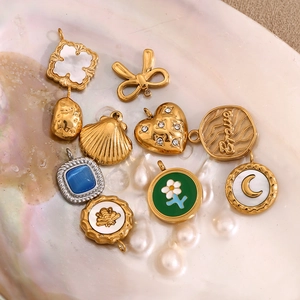 Detailansicht von Vintage-Anhängern mit 18K Vergoldung, Muscheln und Zirkon-Besatz