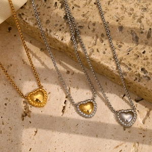 Detailed close-up of heart necklaces with rope texture edges in gold and silver finishes