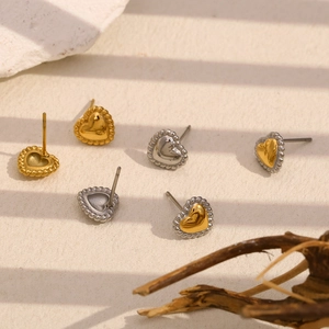 Detailed view of heart-shaped stud earrings in gold and silver with beaded edges