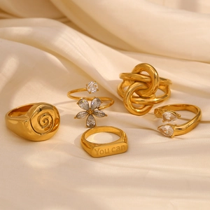 Set of five 18K gold plated stainless steel rings with white crystals and shell knot design