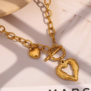 Detailed shot of gold-plated OT toggle clasp and textured hollow heart pendant on necklace