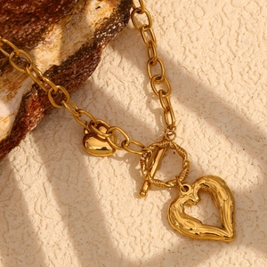 Chunky gold O-chain necklace featuring textured heart pendants and toggle clasp closure