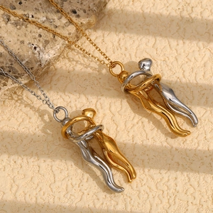 Detail of 18K gold plated lovers hugging pendant necklaces with two-tone polished finish