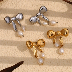 Dettaglio degli orecchini a farfalla placcati oro 18K con eleganti perle a goccia bianche