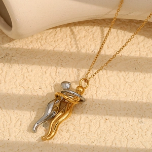Macro shot of gold and silver two-tone lovers hug pendant on stone background