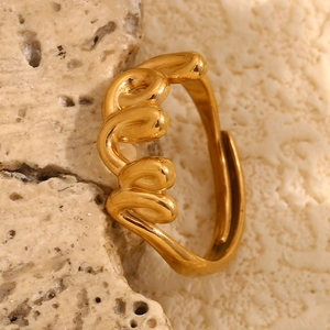 Detailed close-up of a wavy 18K gold-plated stainless steel ring on a stone