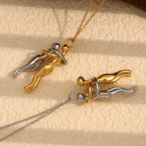 Lovers hugging pendant necklaces in 18K gold and silver tones on stone background