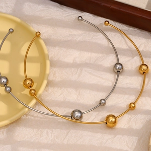 Dettaglio di collane torque minimaliste in oro 18 carati e argento con perle