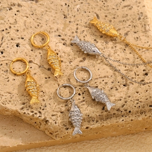 Detail view of 18K gold and silver koi fish pendant earrings with sparkling crystals