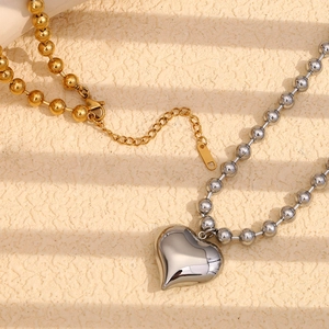 Vue macro de pendentifs cœur en or 18 carats et argent avec chaînes à billes polies