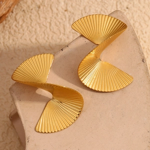 Macro detail of gold fan earrings featuring a textured 3D twisted spiral design