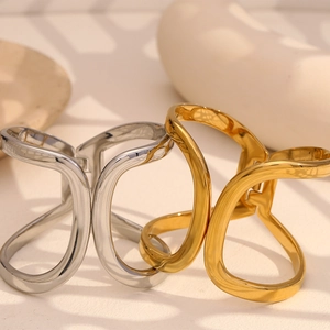 Detail showing two fluid liquid metal style hair claws in gold and silver plating