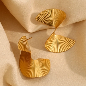 Macro detail of 18K gold plated twisted fan earrings with elegant ribbed texture stripes