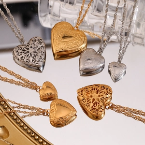 Détail de divers médaillons en forme de cœur en or 18 carats et argent gravés