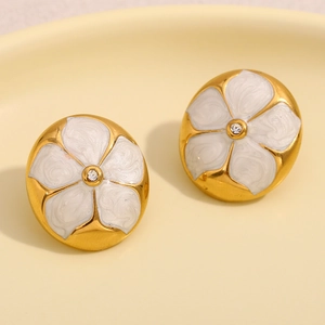 Gros plan détaillé des boucles d'oreilles fleur plaquées or 18K avec émail blanc et strass