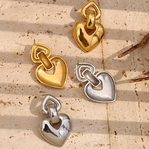 Vue détaillée de boucles d'oreilles cœur en or et argent polis sur pierre