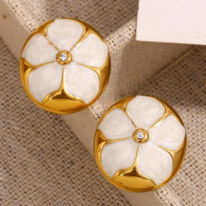 Gros plan de boucles d'oreilles fleur plaqué or 18K avec émail blanc et petit cristal