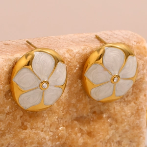 Macro de boucles d'oreilles fleur plaquées or avec émail blanc et cristal brillant