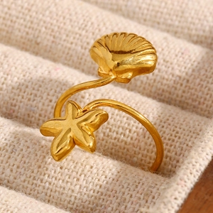 Dettaglio macro di stella marina e conchiglia placcate oro 18K su anello aperto