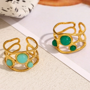 Detailed macro view of 18K gold plated hollow mesh rings with green gemstone accents