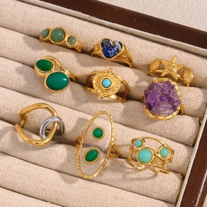 Macro detail of a 9-piece gold-plated ring set with starfish, shells, and turquoise stones