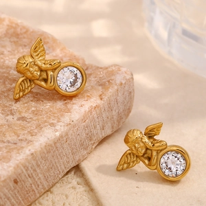 Détail de boucles d'oreilles ange en or avec zircon cubique sur support en pierre