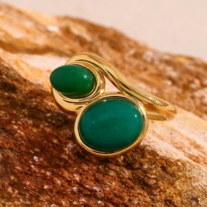 Macro detail of 18K gold-plated double green gemstone ring on natural stone background