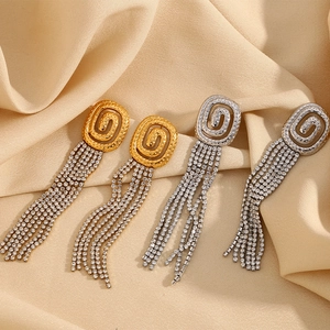 18K gold plated tassel earrings with sparkling crystals shown on champagne satin fabric