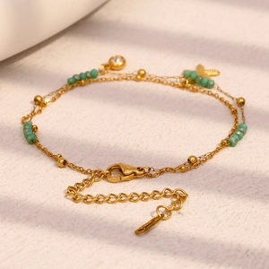 Detail eines 18K vergoldeten doppelten Seestern-Armbands mit Türkisperlen und Karabinerverschluss