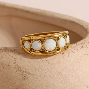 Detail of 18K gold plated ring featuring five white opals on a ceramic dish edge