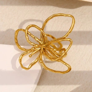 Dettaglio macro dell'anello floreale cavo placcato oro 18 carati su supporto geometrico bianco