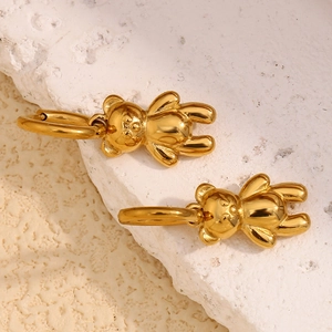 Macro shot of polished 18K gold plated stainless steel 3D teddy bear hoop earrings